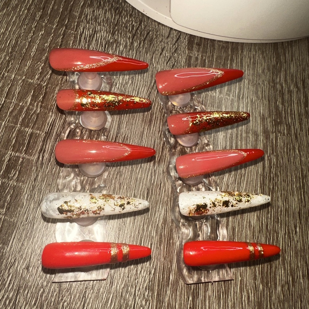 Red and gold stiletto nails! 2 white marbled nails with gold flakes! Gorgeous!